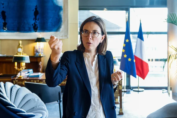 Amélie de Montchalin dans un bureau officiel, illustrant son parcours politique.