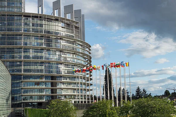 Bâtiment du Parlement européen (Louise Weiss) à Strasbourg avec des drapeaux nationaux.