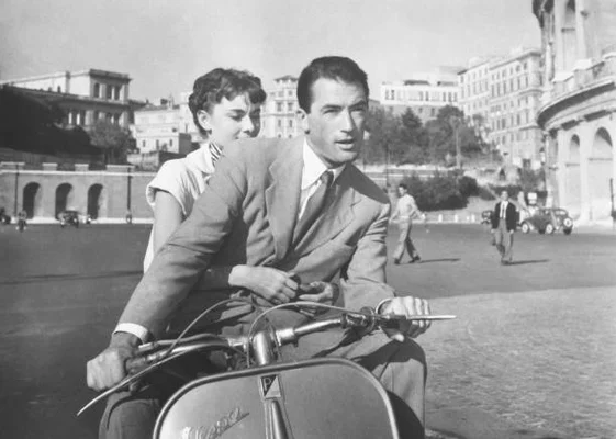 Audrey Hepburn and Gregory Peck riding Vespa scooter around Rome in a scene from the 1953 movie 'Roman Holiday'.