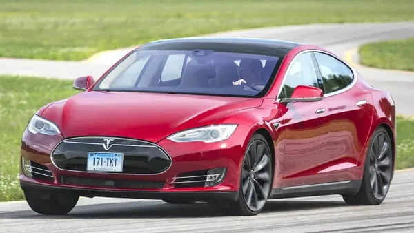 Tesla Model S sedan driving on road, representing the company's innovative history