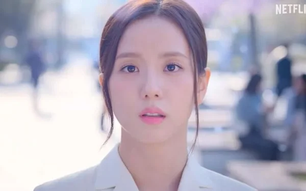 Jisoo en veste claire sur fond de rue flou, capture d'écran de la production.
