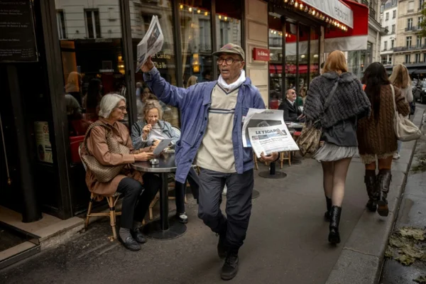 Ali Akbar, vendeur de journaux propose des exemplaires de journaux dans une rue du Quartier latin à Paris, le 16 septembre 20