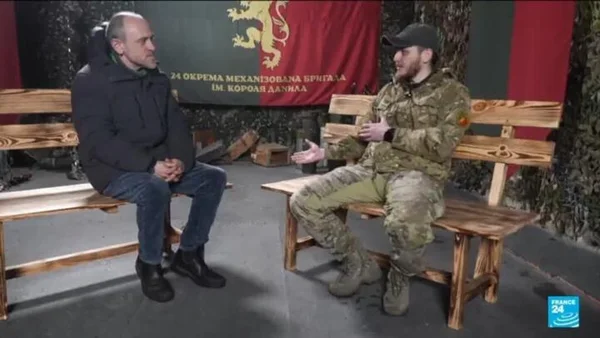 Interview de deux personnes, dont un soldat en uniforme militaire, dans les tranchées du Donbass
