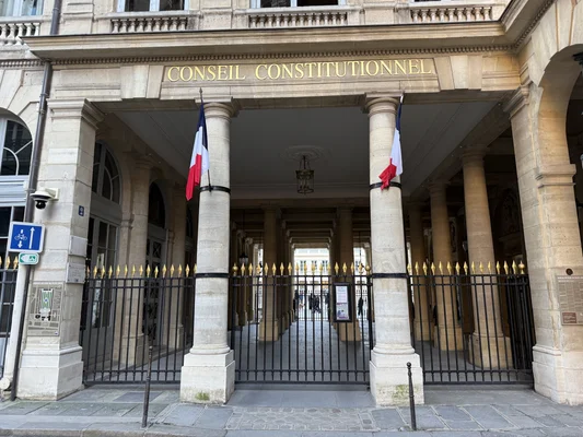 Façade du bâtiment du Conseil constitutionnel à Paris, avec ses colonnes en pierre et l'enseigne officielle.