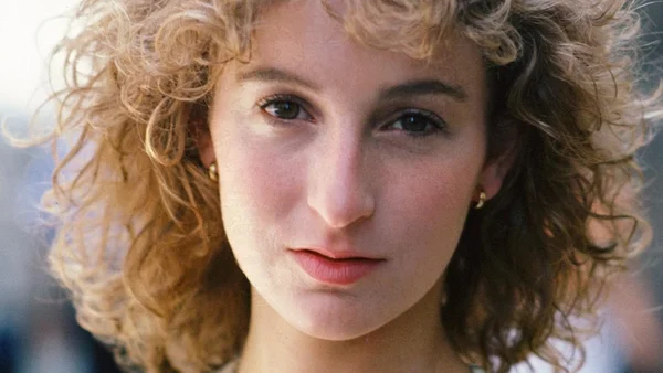 Jennifer Grey smiling naturally at age 65 looking radiant.