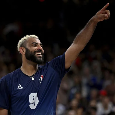 Earvin Ngapeth en maillot de club bleu marine, célébrant face au public.