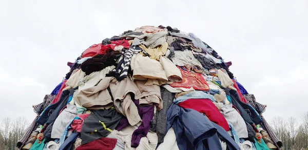 Large pile of discarded clothing representing fast fashion textile waste