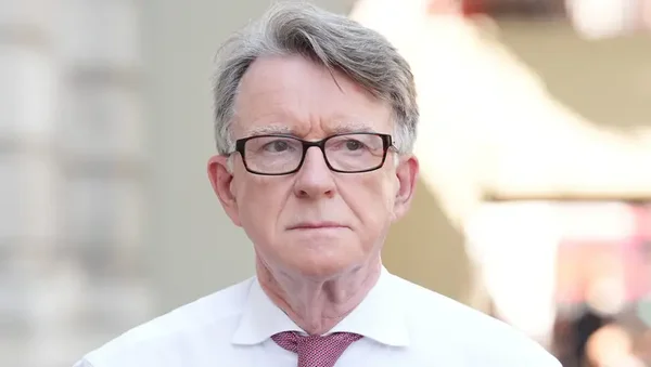 Peter Mandelson en chemise blanche et cravate rouge.