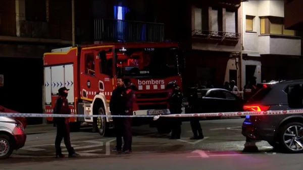 Un camion des pompiers stationné près de rubans de police la nuit