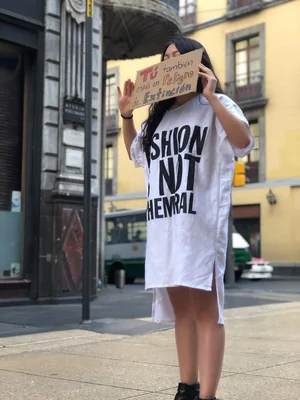 Protester against fast fashion environmental impact holding sign in Mexico City