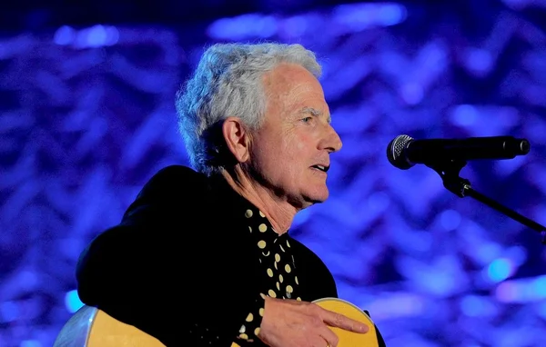 Billy Steinberg avec une guitare devant un micro