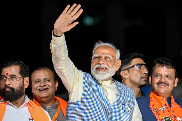 Narendra Modi saluant une foule de supporters lors d'un rassemblement politique nocturne