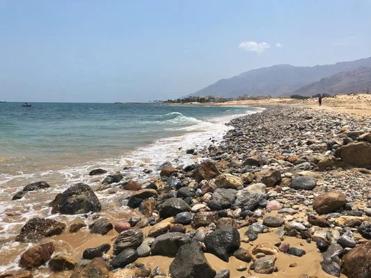 Le rivage de la mer d'Oman, avec les montagnes Al Hajar en arrière-plan.