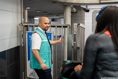 Un agent RATP en gare assistant une usagère.