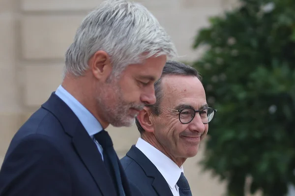 Laurent Wauquiez discutant avec un autre homme en costume lors d'un événement politique