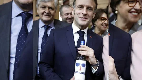 Bouteille de vin étiquetée 'For Sure' avec lunettes de soleil, référence au mème Macron