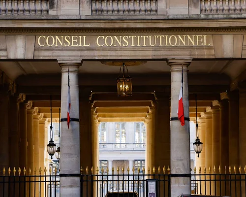 Entrée du Conseil constitutionnel à Paris, identifiable par son architecture classique et son drapeau français.