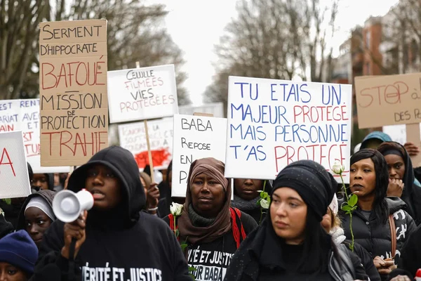 Participants à une marche blanche réclamant justice et protection, avec pancartes et mégaphone