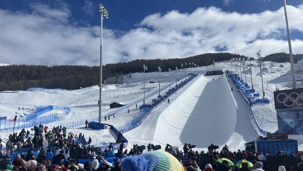 Halfpipe du Livigno Snow Park pour les Jeux Olympiques 2026 avec spectateurs et montagnes enneigées.