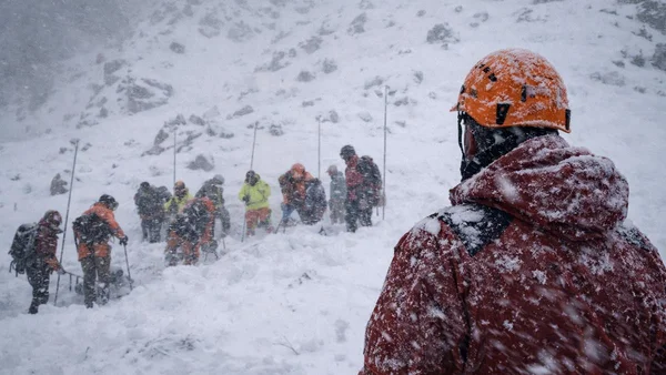 Secouristes travaillant sur un versant montagneux enneigé lors des opérations de recherche en Californie