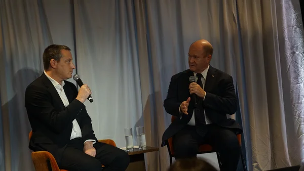 United Nations' top climate official Simon Stiell speaking next to a clock mounted on a wall.