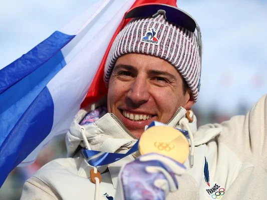 Un athlète français tenant une médaille d'or lors des JO de Milan-Cortina 2026