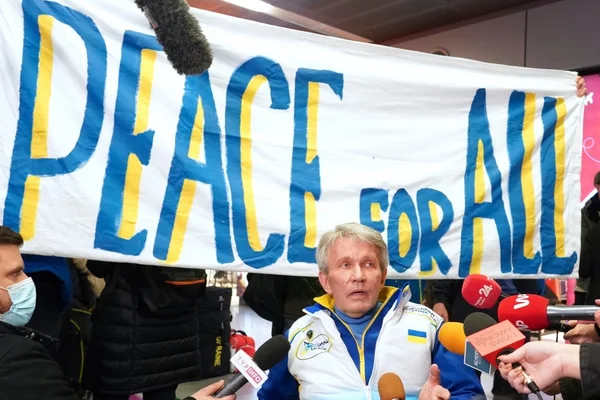 Une conférence de presse devant une banderole 'PEACE FOR ALL' pour protester contre la participation russe.