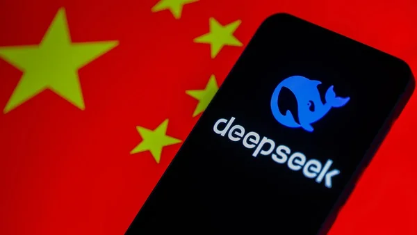 Smartphone affichant le logo DeepSeek sur fond de drapeau chinois rouge