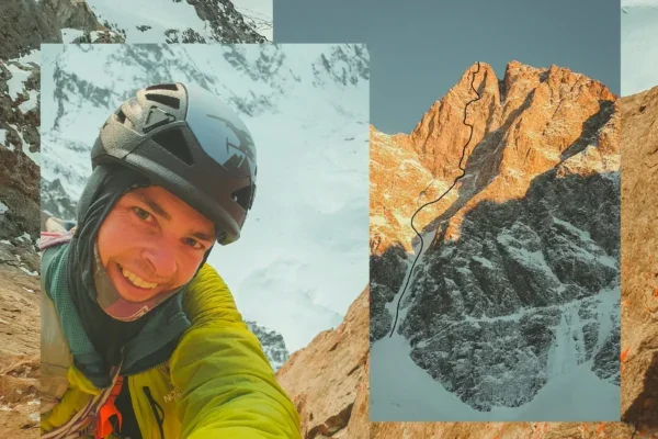 Un alpiniste prenant un selfie avec des pics rocheux en arrière-plan.