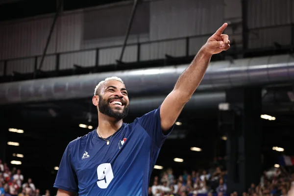 Earvin Ngapeth en maillot de l'équipe de France, souriant et montrant le ciel.