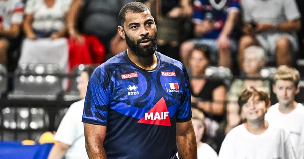 Earvin Ngapeth portant le maillot de l'équipe de France dans une salle omnisports.