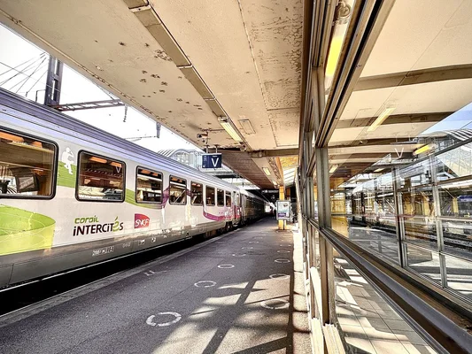 Train Intercités Corail stationné sur un quai de gare avec le logo SNCF