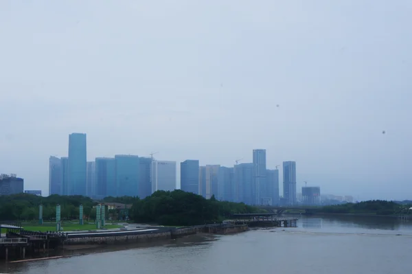 Panoramic view of Yiwu's modern skyline with high-rise buildings along a riverfront.