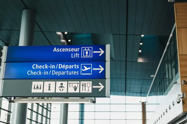 Panneau directionnel dans un aéroport indiquant les check-in et les départs