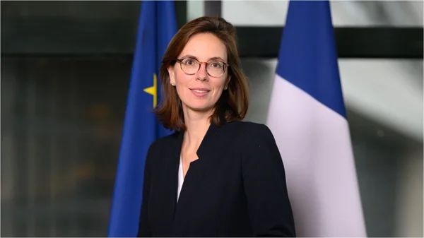 Portrait officiel d'Amélie de Montchalin devant les drapeaux européen et français