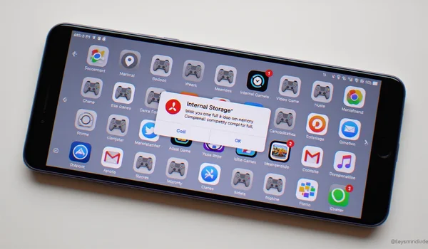 Smartphone affichant un message d'erreur de stockage plein avec des icônes de jeux vidéo et d'applications en grisé, espace disponible à zéro