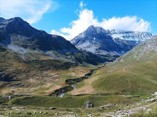 Village de Champagny-en-Vanoise dans une vallée alpine entourée de forêts.
