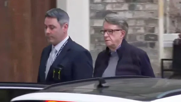 Deux hommes marchant à l'extérieur, dont Peter Mandelson.