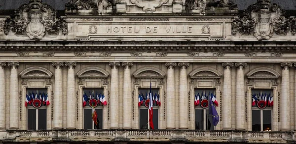 Façade d'un hôtel de ville avec des drapeaux français pour les municipales 2026