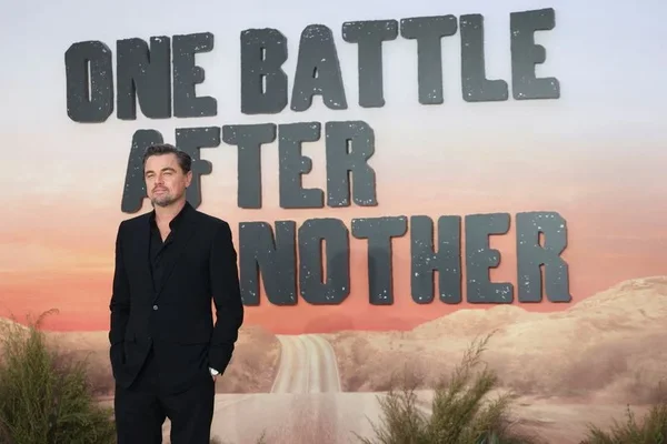 Un homme en costume noir devant le décor du film Une bataille après l'autre