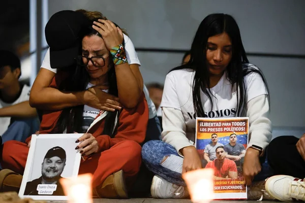 Femmes lors d'une veille tenant la photo de Justo Daza Gedeón et une banderole.