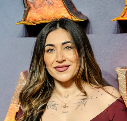 Ellie Prohan poses on the blue carpet at the London premiere of Avatar: Fire and Ash.