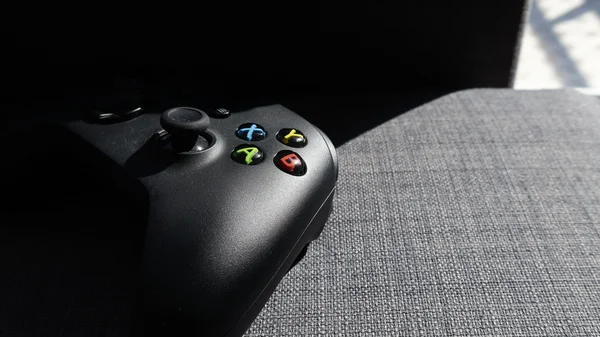 Trois manettes Xbox vertes, violettes et orange.