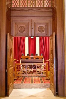 Le président Emmanuel Macron lors d'une allocution formelle devant les drapeaux français et européens.