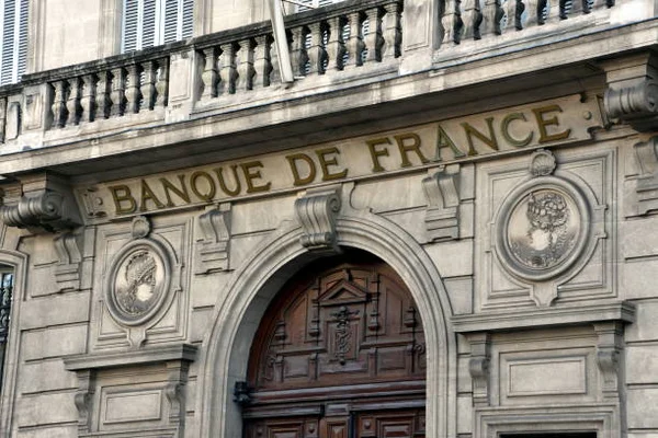 Mains d'un jeune tenant un livret d'épargne ou son téléphone.