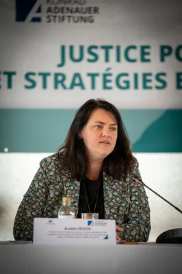 Aurélia Devos assise à une table avec un micro lors d'un événement sur la justice.