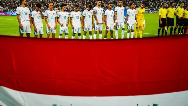 L'équipe d'Iran alignée sur le terrain avant un match, avec le drapeau national en évidence.