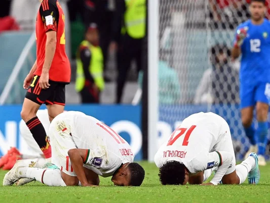 Des joueurs de football prient sur la pelouse lors d'un match