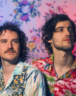 Un duo romantique et pop français portant des chemises colorées.