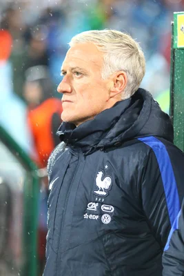 Didier Deschamps, en tenue d'entraîneur des Bleus, lors d'un match au stade sous une pluie battante.